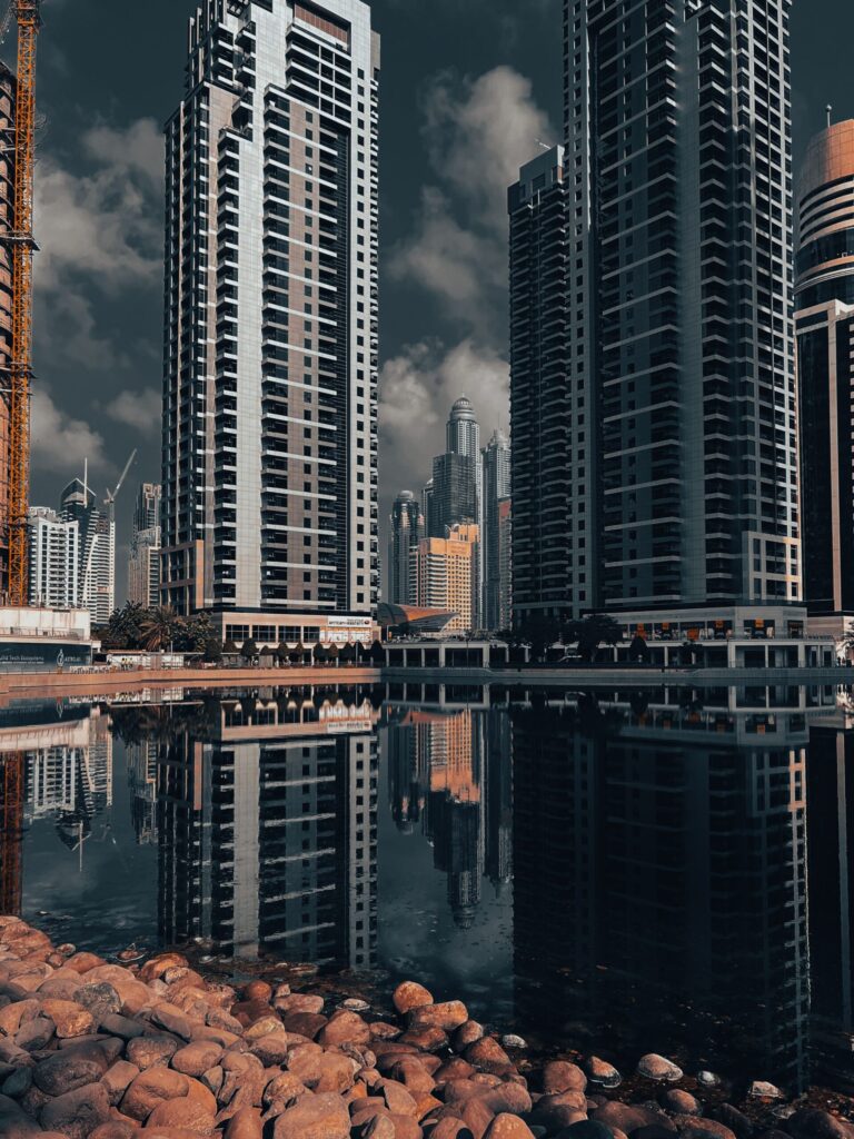 Moody dusk-toned reflection of Dubai high-rise towers on still water