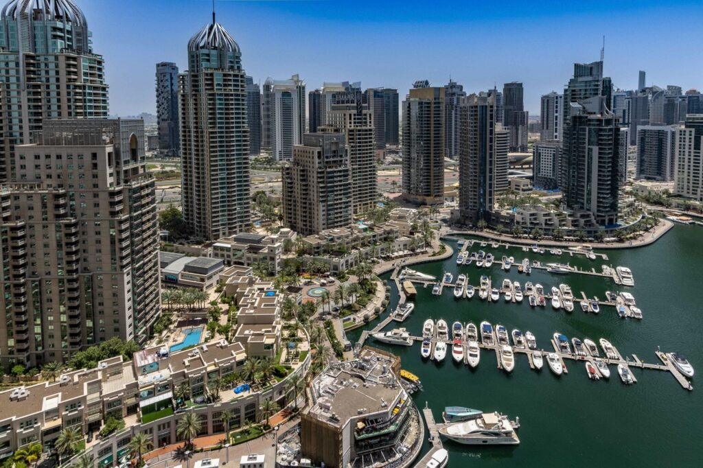 Aerial view of Dubai Marina skyline with residential towers and yachts docked along the waterfront