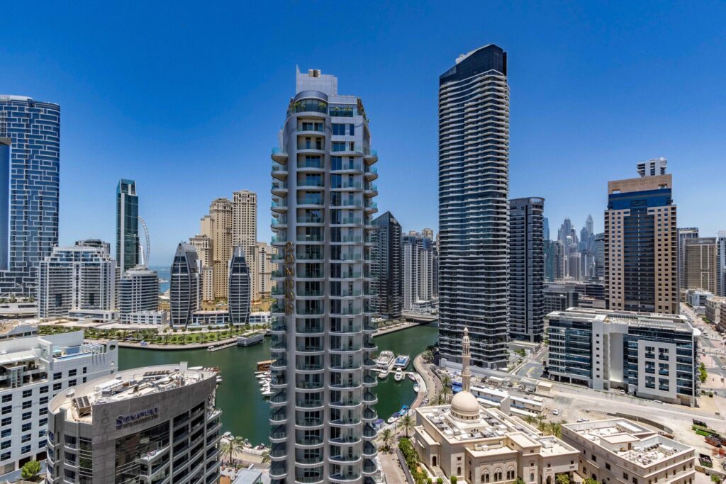 Residential skyscrapers and waterfront in Dubai Marina under a clear blue sky