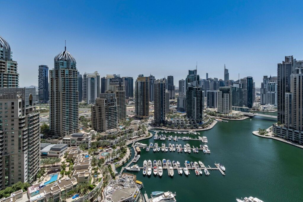 Aerial view of towers and a marina under a clear blue sky in Dubai
