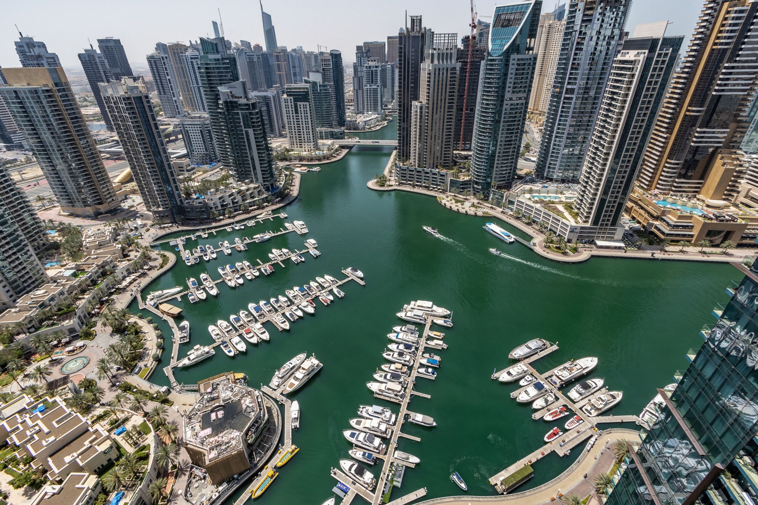 Aerial daytime view of the Dubai Marina waterfront skyline and yacht-lined lagoon, representative of La Residencia Del Mar's Marina setting