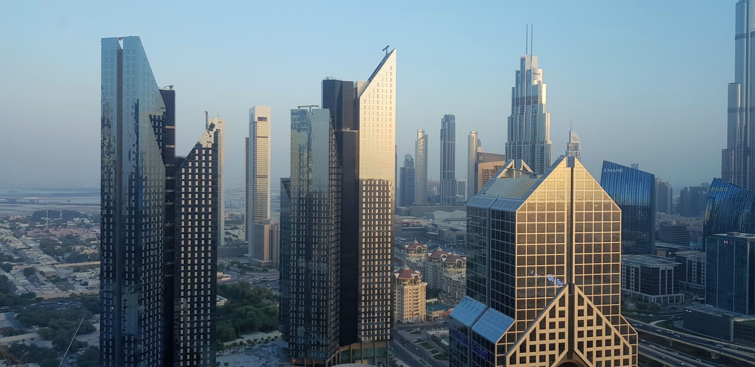 Daytime aerial view of Downtown Dubai skyscrapers along Sheikh Zayed Road with Burj Khalifa visible in the distance, no people visible