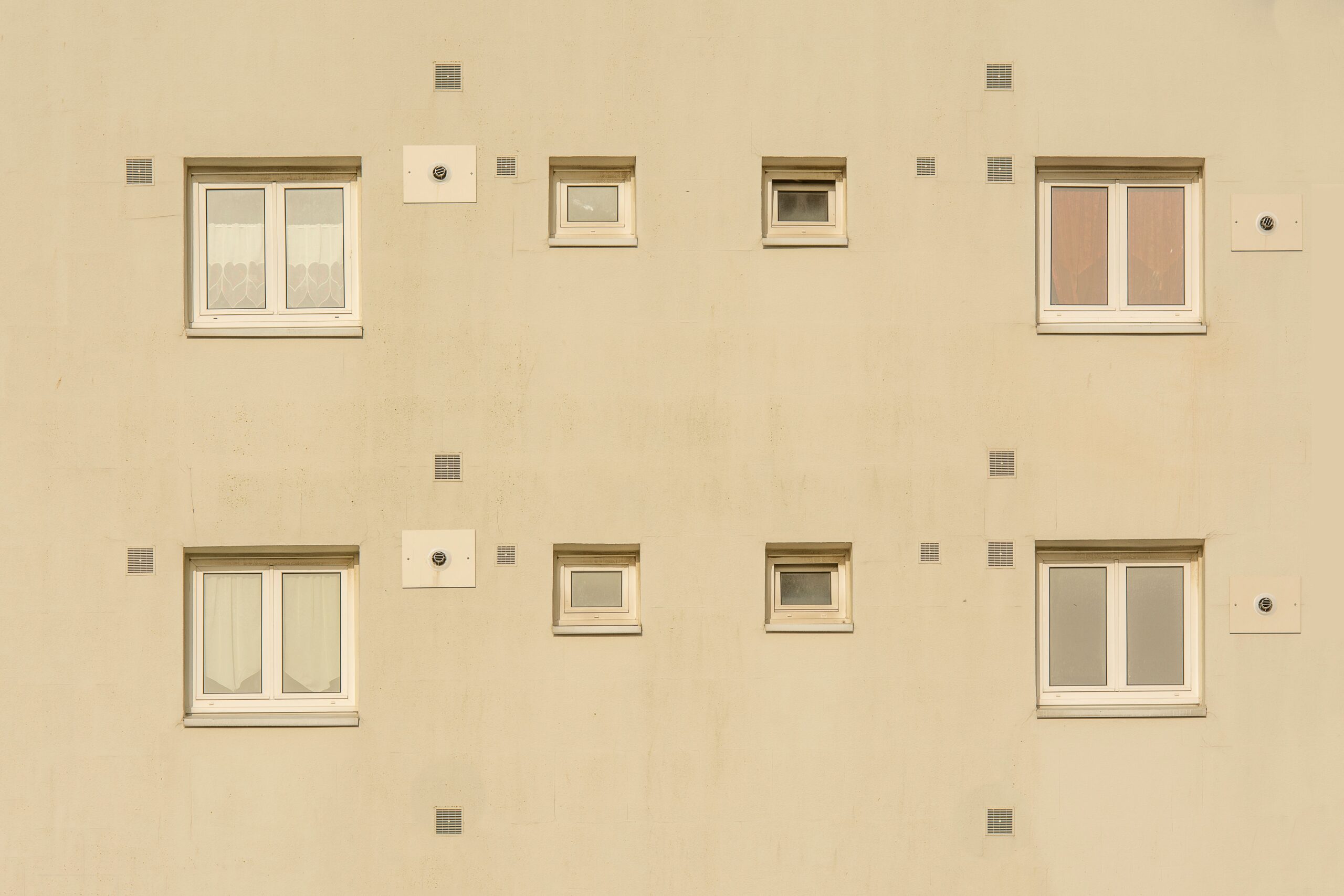Close-up of a beige apartment building facade in Dubai with symmetrical windows