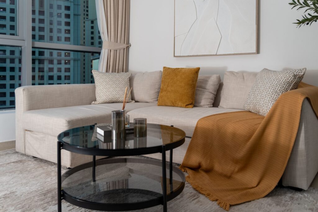 Modern furnished living room interior with city tower view through the window, in a Dubai apartment