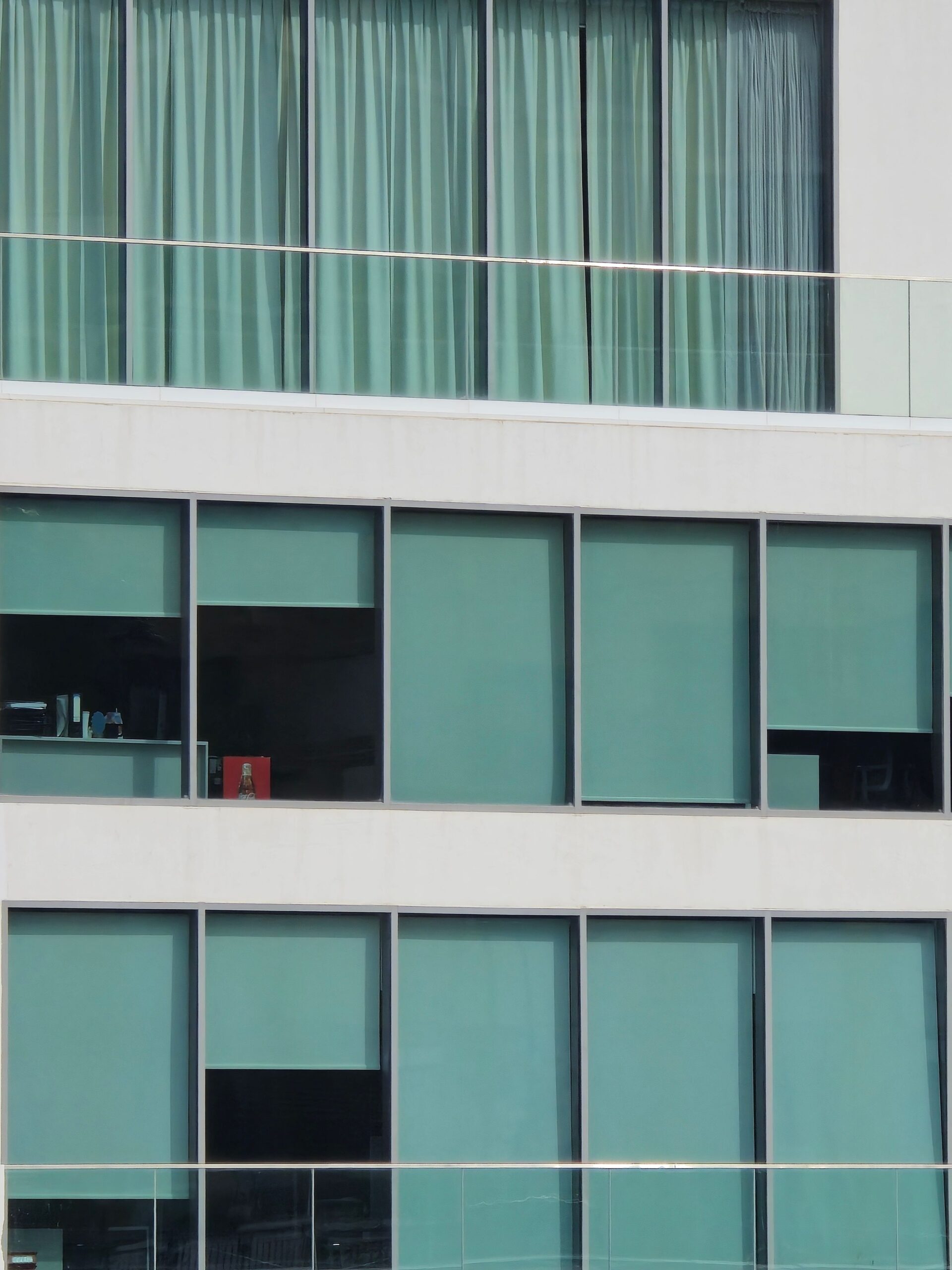 Close-up of a modern apartment building facade with reflective glass windows in Dubai