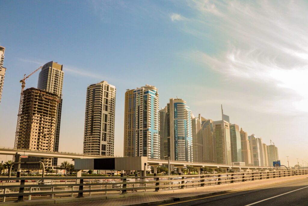 Daytime view of a Dubai high-rise skyline with one tower still under construction, near Six Senses Residences Dubai Marina