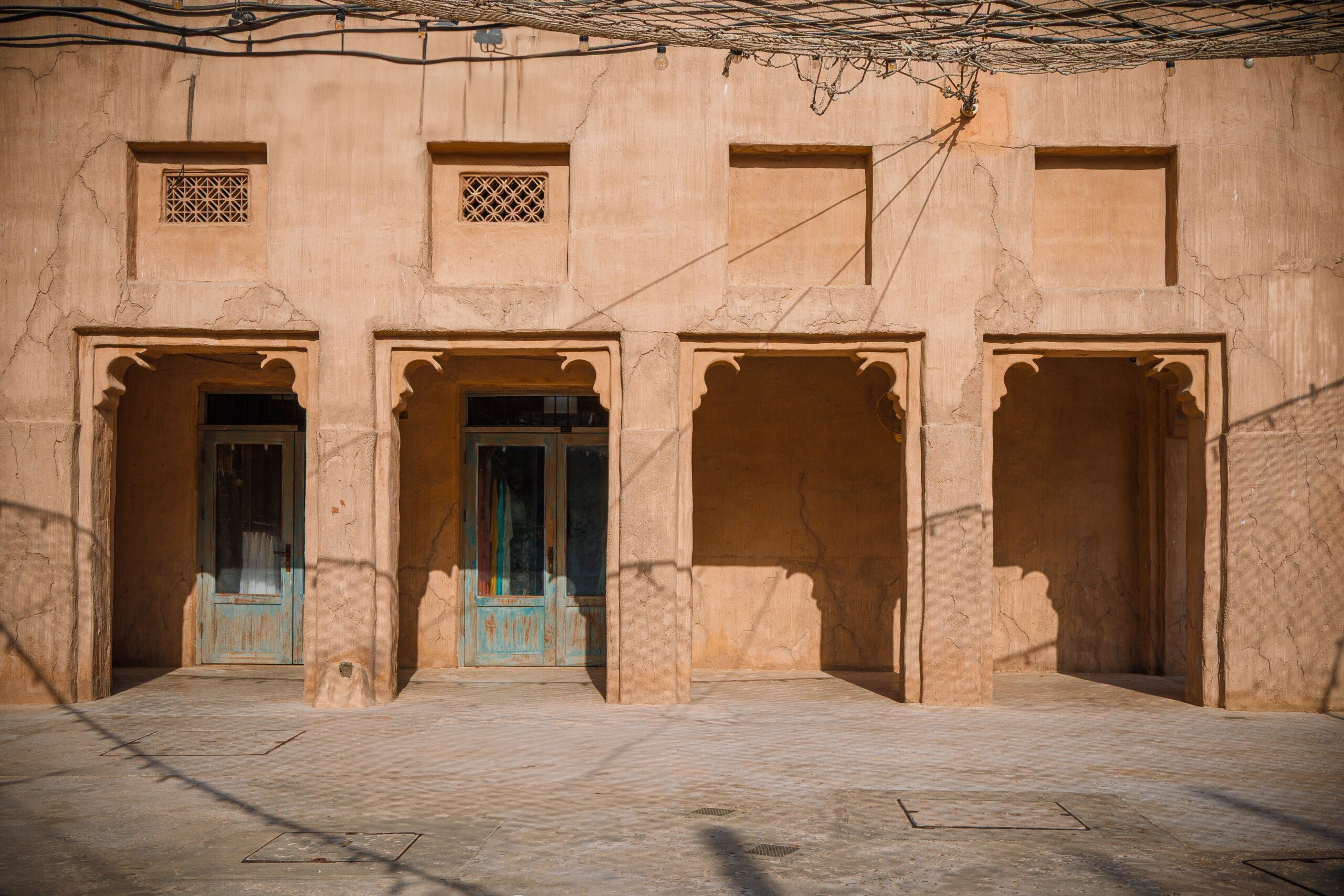 Sandstone Old Town-style courtyard with carved arched doorways in Downtown Dubai, near Miska 1