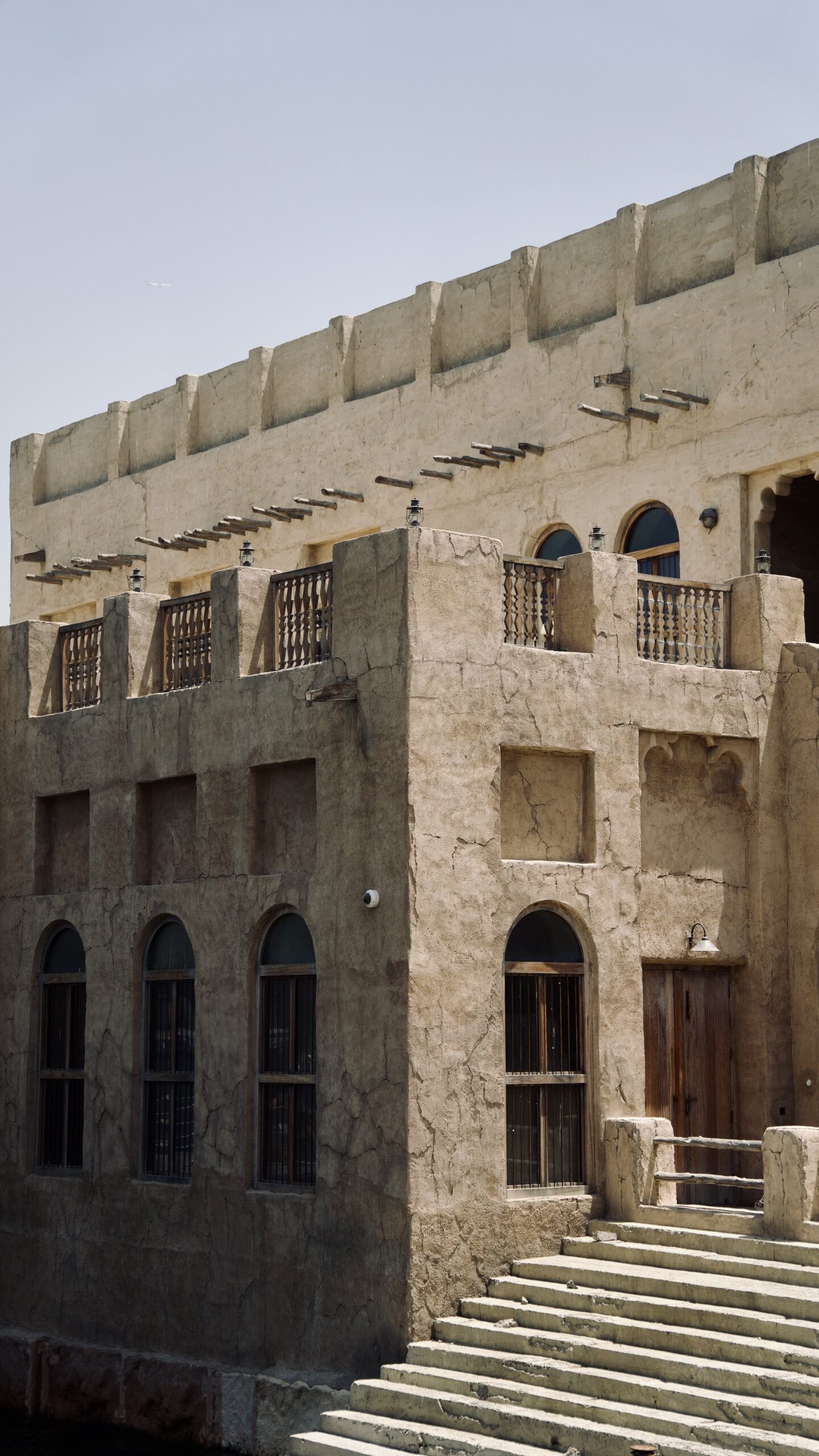 Historic sandstone apartment building with arched windows and wrought iron balconies in Old Town, Downtown Dubai, near Kamoon 4