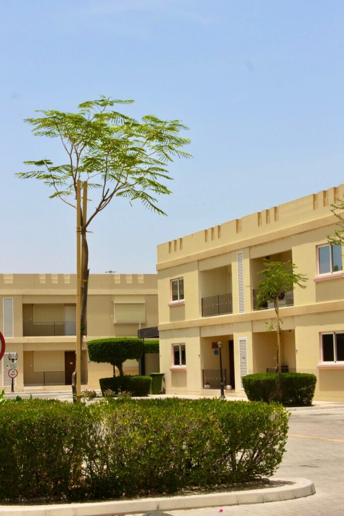 Beige low-rise townhouse block behind a landscaped garden path near Diamond Views 2, JVC