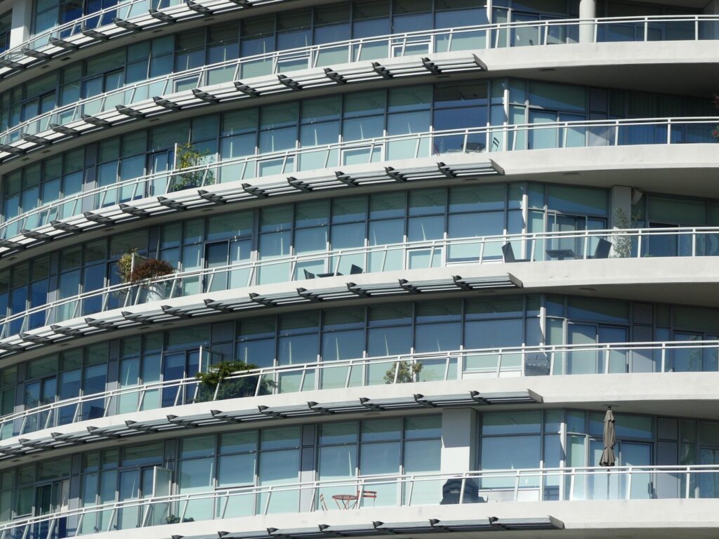 Close-up curved glass facade with balconies on a modern high-rise residential tower, in the architectural style found across Dubai Marina's newer waterfront towers