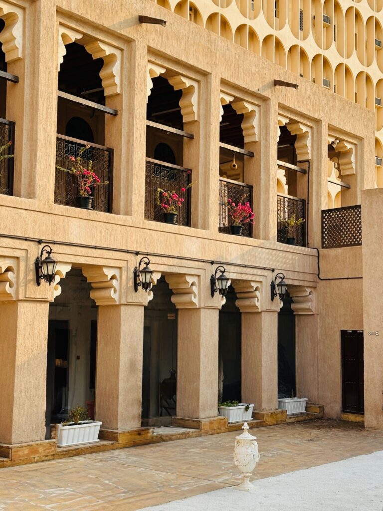 Sandstone-toned Arabian-style courtyard building facade with arched balconies, typical of Old Town Downtown Dubai, near Zaafaran 3