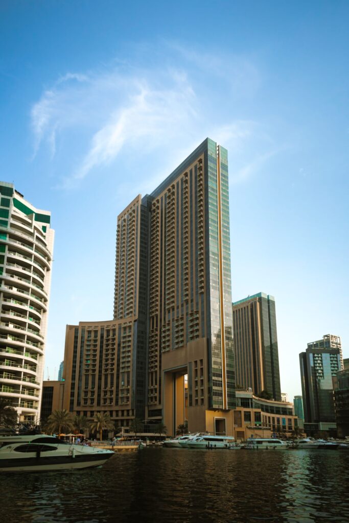 Modern skyscrapers and luxury yachts in Dubai Marina under a clear blue sky
