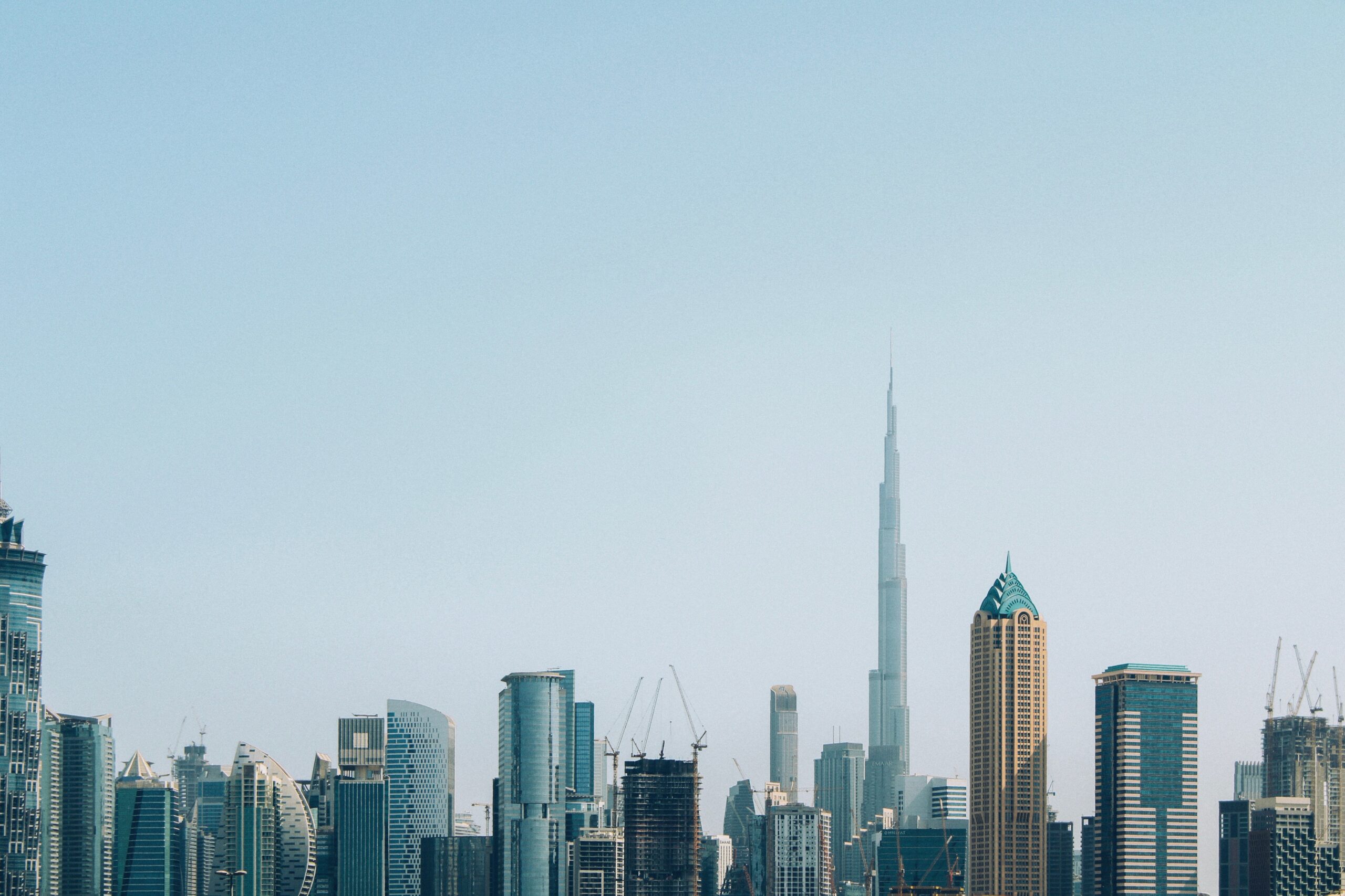 Dubai skyline with the Burj Khalifa and construction cranes, representative of the Business Bay area where Canal Crown is under construction