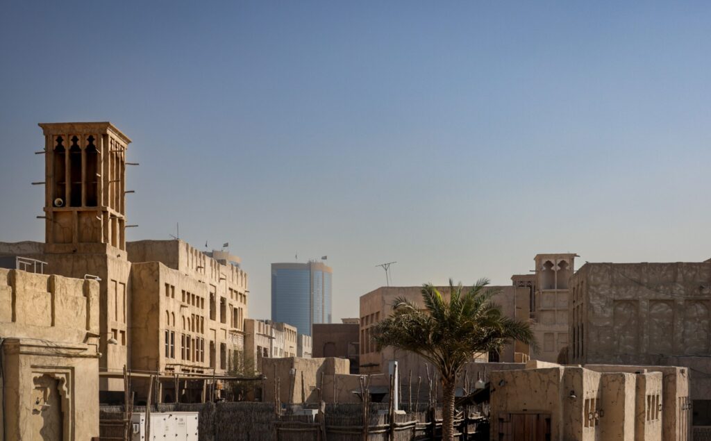 Bastakiya-style wind-tower buildings against the Downtown Dubai skyline, evocative of Old Town near Zanzebeel 4