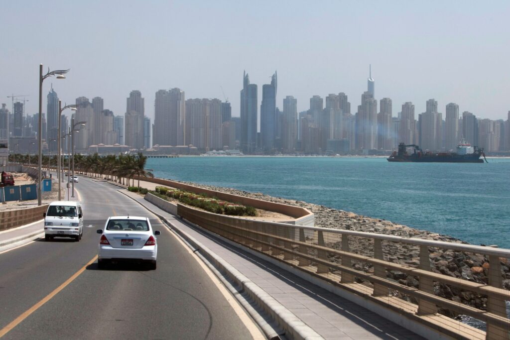 Palm Jumeirah's Trunk road with the Dubai Marina and JBR skyline across the water, near Muraba Residences on the Eastern Crescent