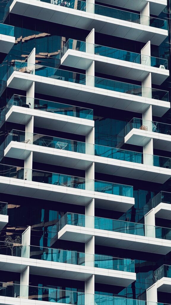 Modern glass and white balcony facade of a Dubai residential tower at dusk