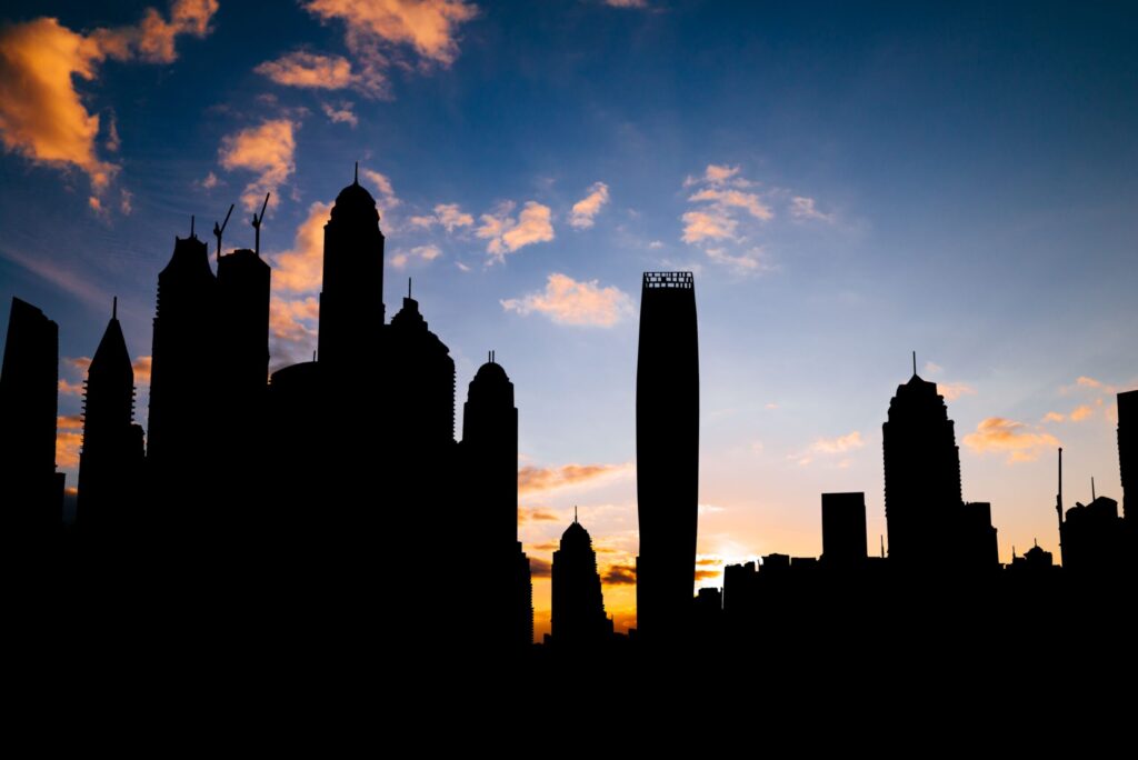 Silhouette of a Dubai city skyline against a vivid blue and orange sky