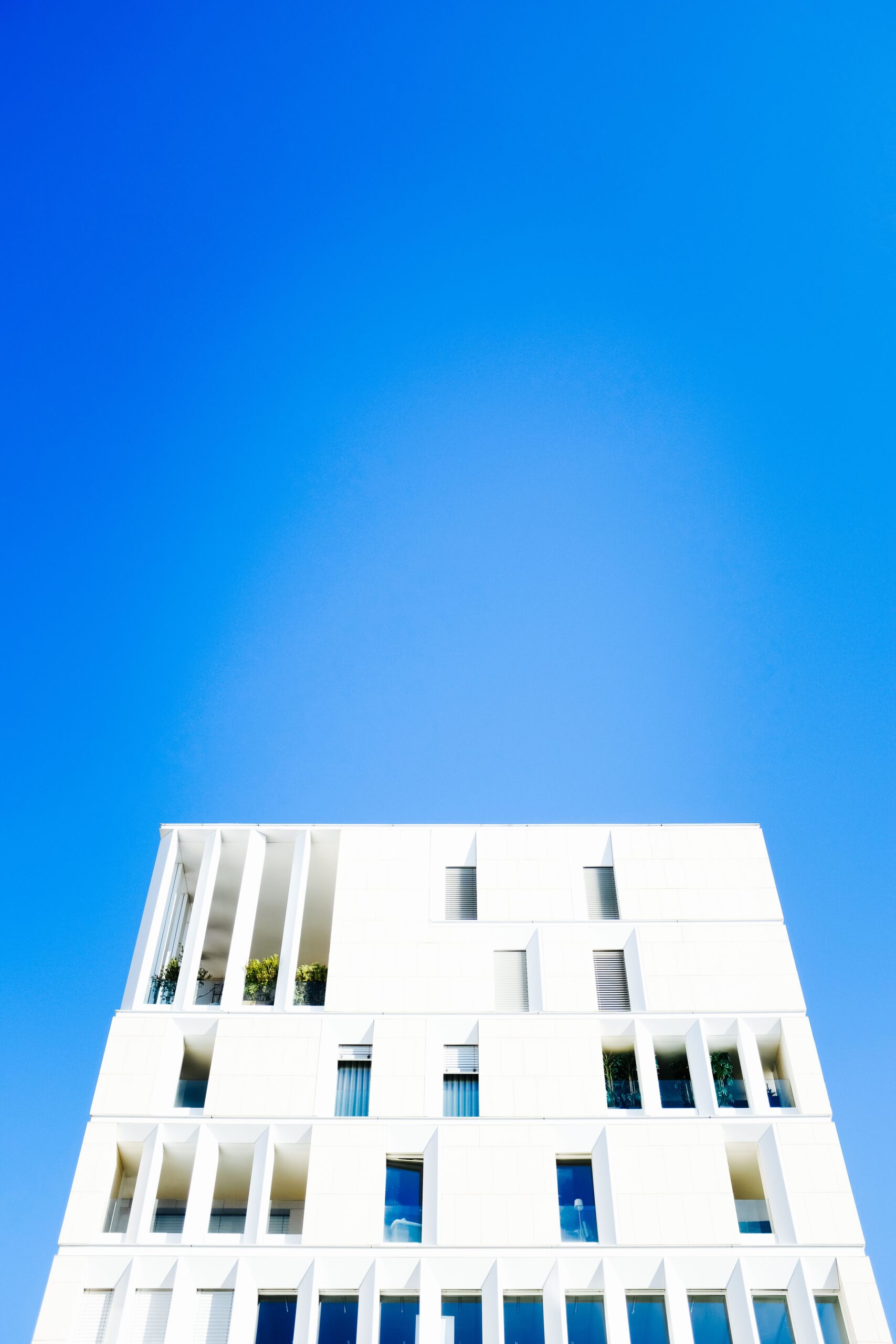 Modern white low-rise apartment building against a bright blue sky in Dubai