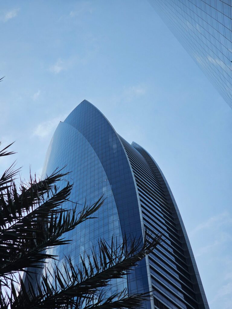 Elegant modern residential building with curved facade reflecting the clear blue sky in Dubai