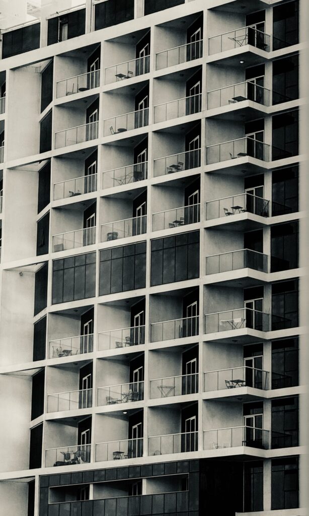Grid of balconies on a monochrome modern apartment building facade, representative of Oasis Star in Dubai Silicon Oasis, Dubai