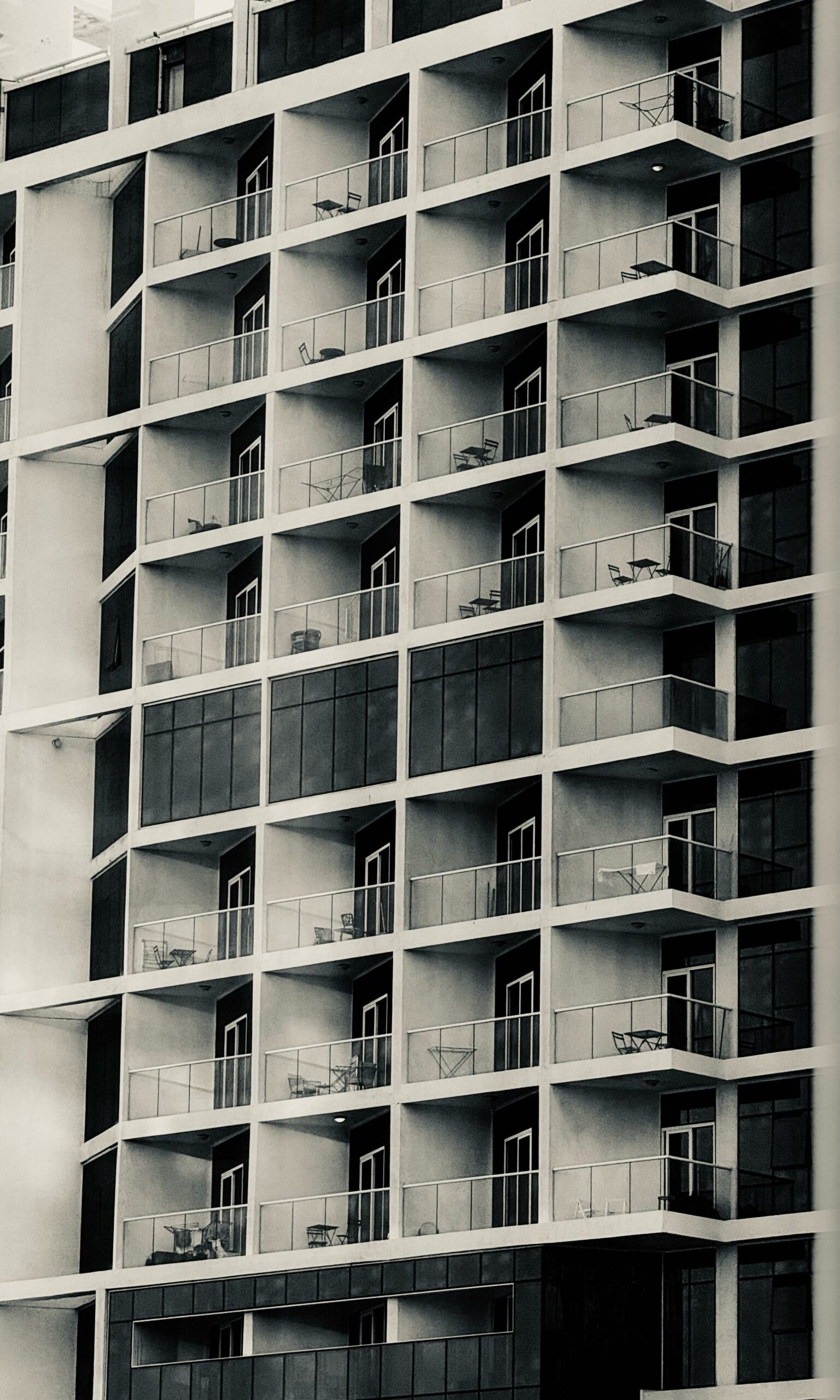 Grid of balconies on a monochrome modern apartment building facade, representative of Oasis Star in Dubai Silicon Oasis, Dubai