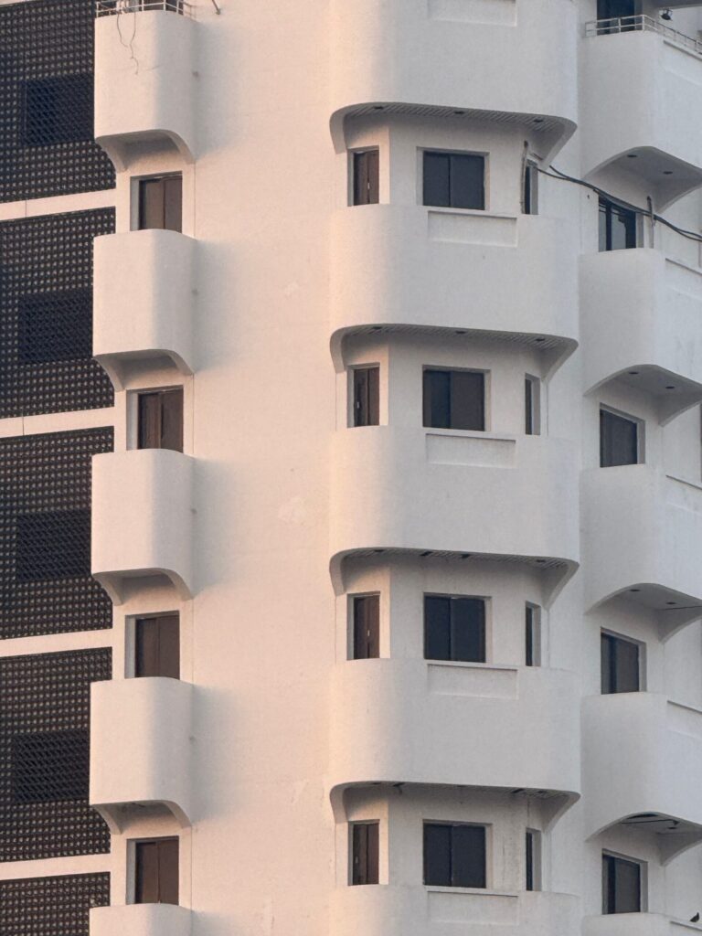 Close-up of a modern white apartment building facade with geometric balconies, similar in style to Haven Residences, JVC