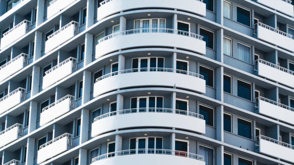 Curved white balconies on a modern apartment facade against a blue sky