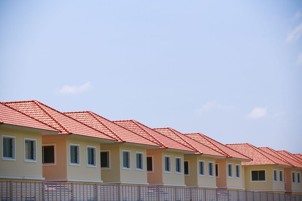 Row of terracotta-roofed townhouses under a clear sky near Mirabella 8, JVC