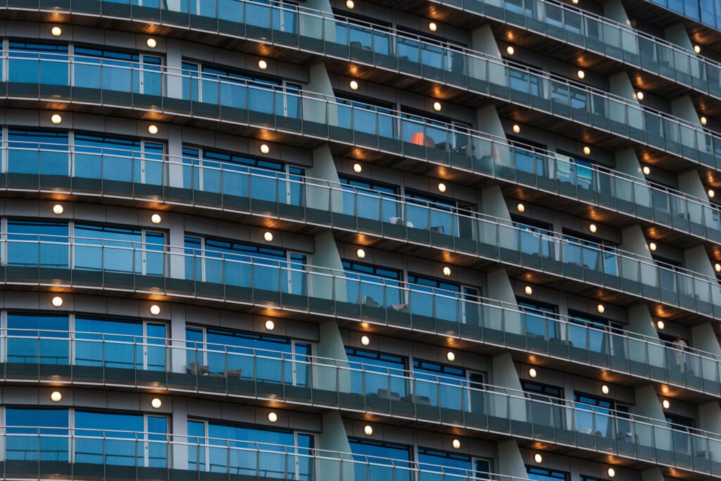 Close-up of a modern curved high-rise facade with lit balconies at dusk, in the architectural style found across Dubai Marina's newer waterfront towers