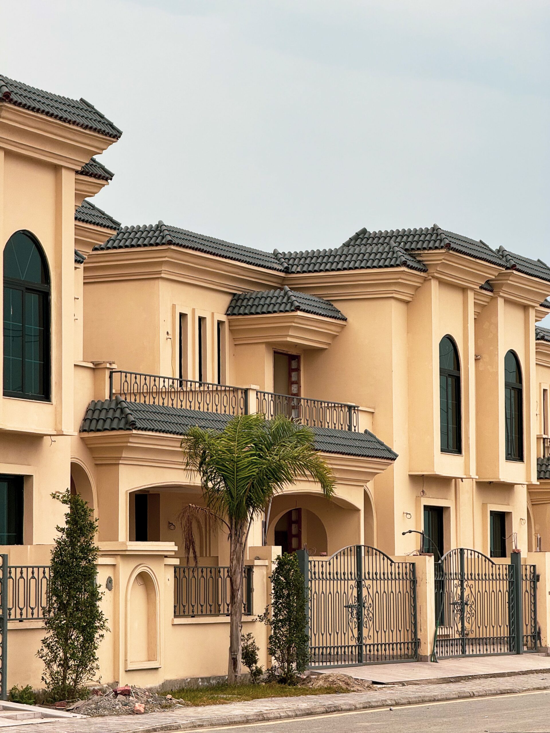 Two-storey Mediterranean-style villa exterior with terracotta tile roofing and wrought-iron balcony railings, in the architectural style found across Dubai's Dubailand villa communities