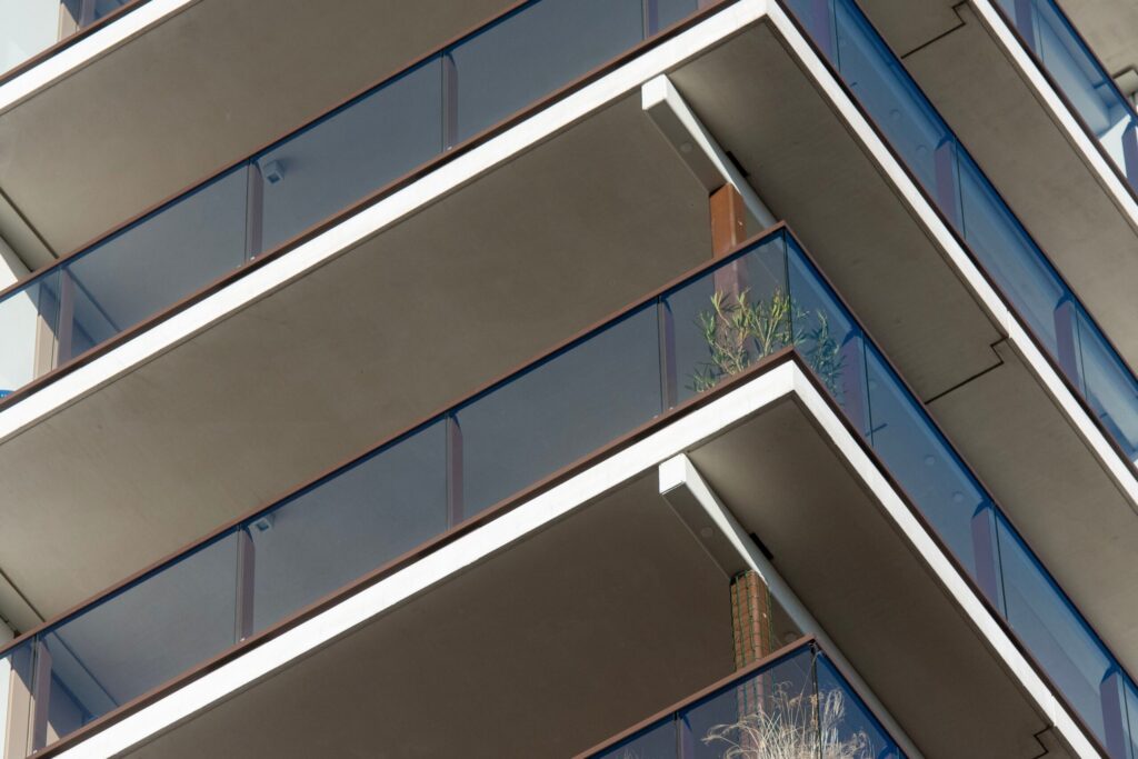 Glass balconies angled across the corner of a modern apartment building
