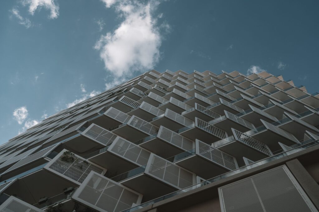 Upward view of a modern Dubai apartment tower facade with angular balconies, similar to the residential style of 399 Hills Park in Dubai Hills Estate