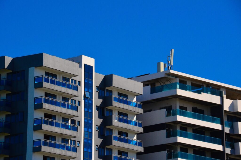 Apartment buildings with blue glass balconies against a deep blue sky