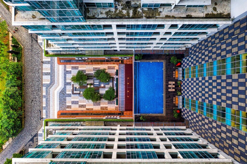 Aerial view of apartment towers around a courtyard with a swimming pool