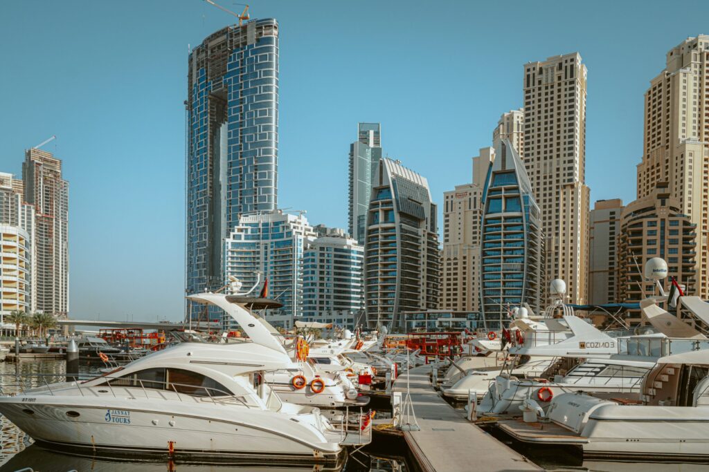 Daytime view of yachts moored in Dubai Marina with residential towers in the background