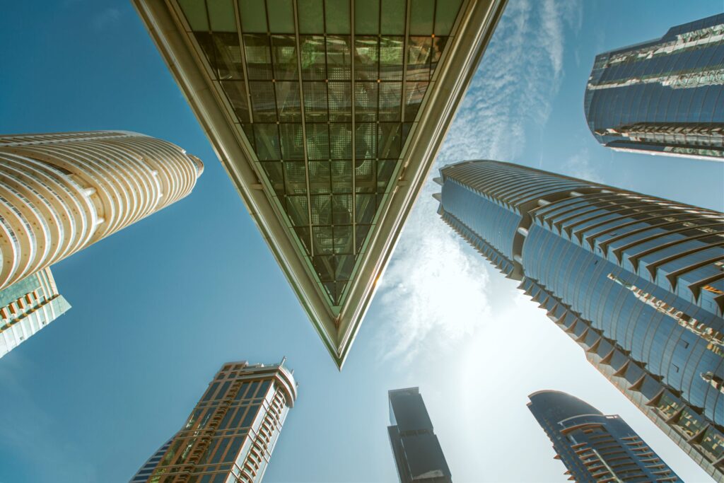 Upward view of Jumeirah Lake Towers skyscrapers including Almas Tower against a blue sky in Dubai