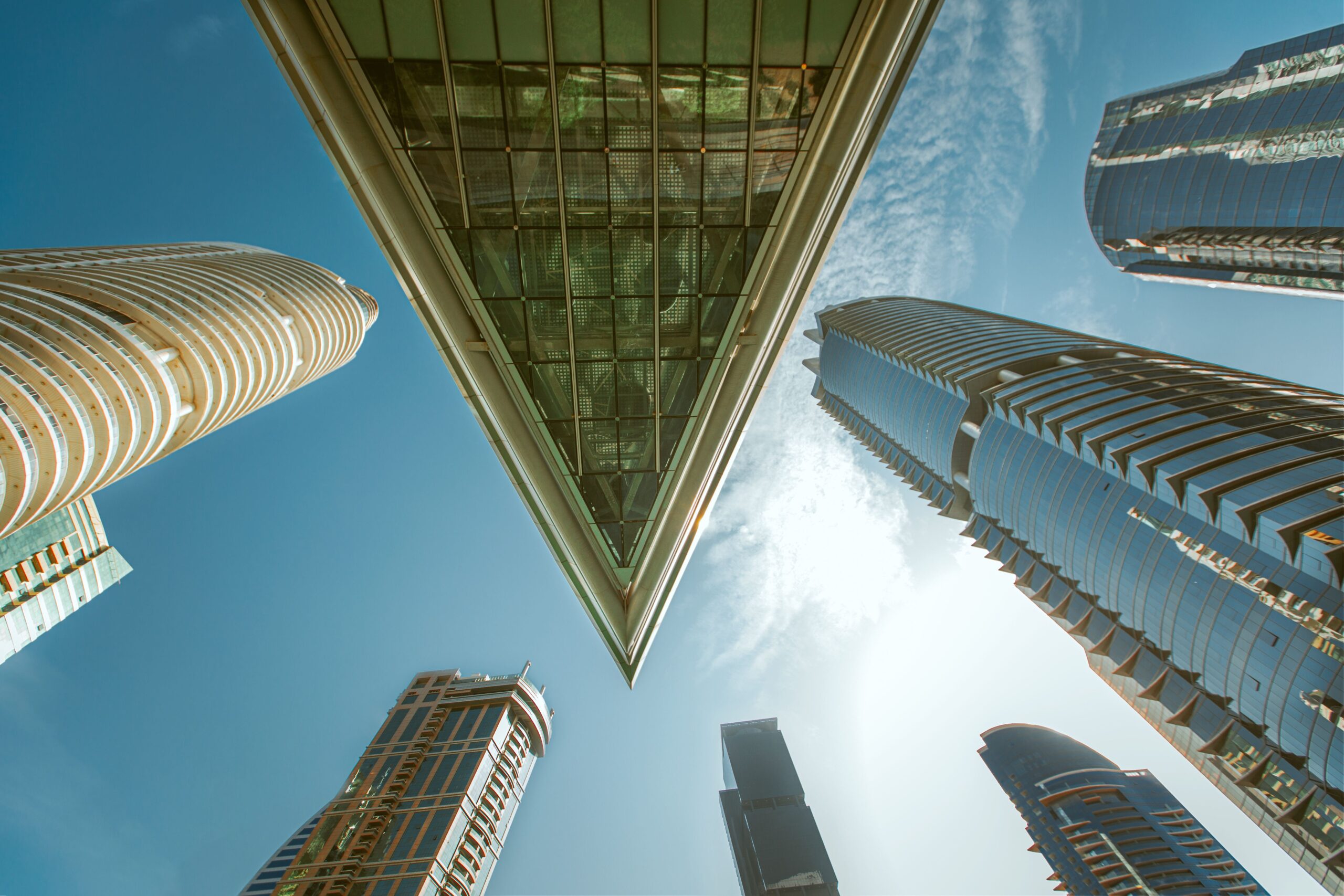 Upward view of Jumeirah Lake Towers skyscrapers including Almas Tower against a blue sky in Dubai