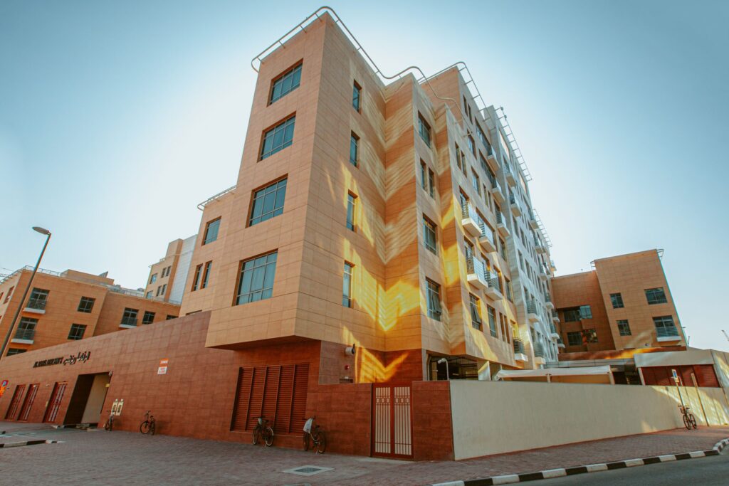 Low-rise beige Dubai apartment building at golden hour near Golden Homes, JVC District 15