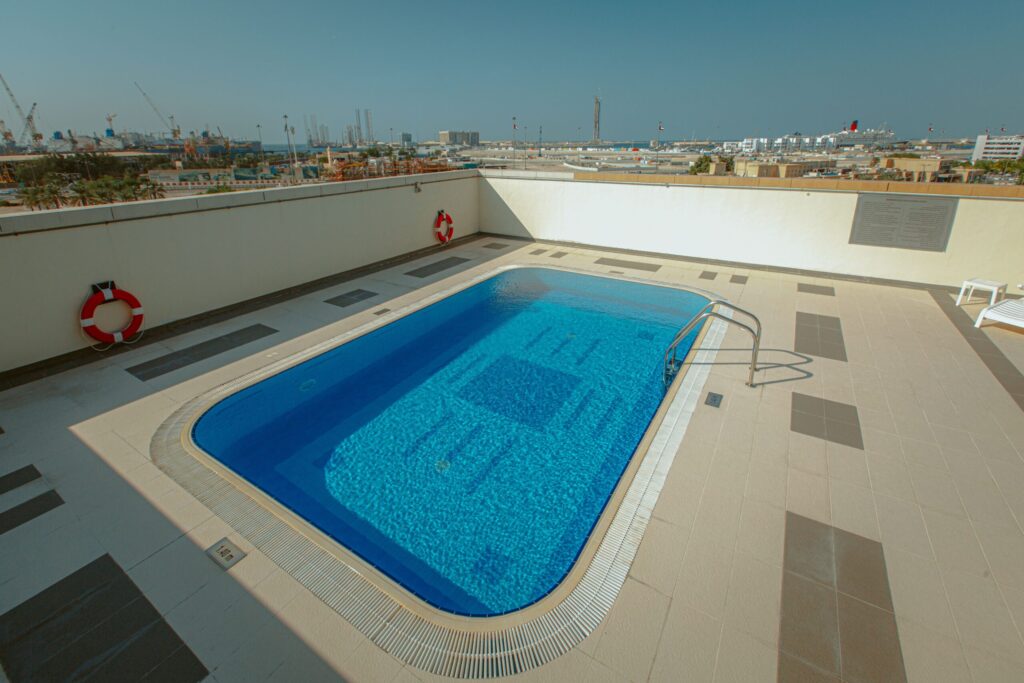 Rooftop swimming pool with city skyline view near Kensington Manor, JVC