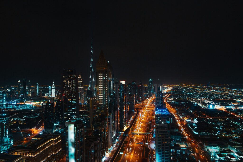 Aerial night view of Dubai's illuminated skyline and highway