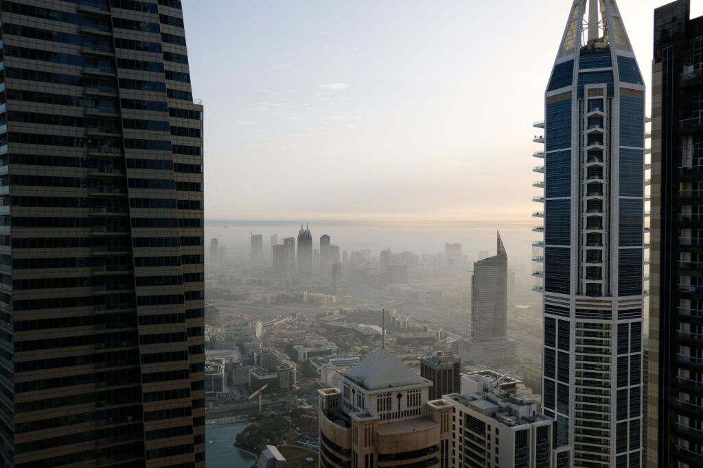 Aerial view of towers and a hazy city skyline at dawn in Dubai