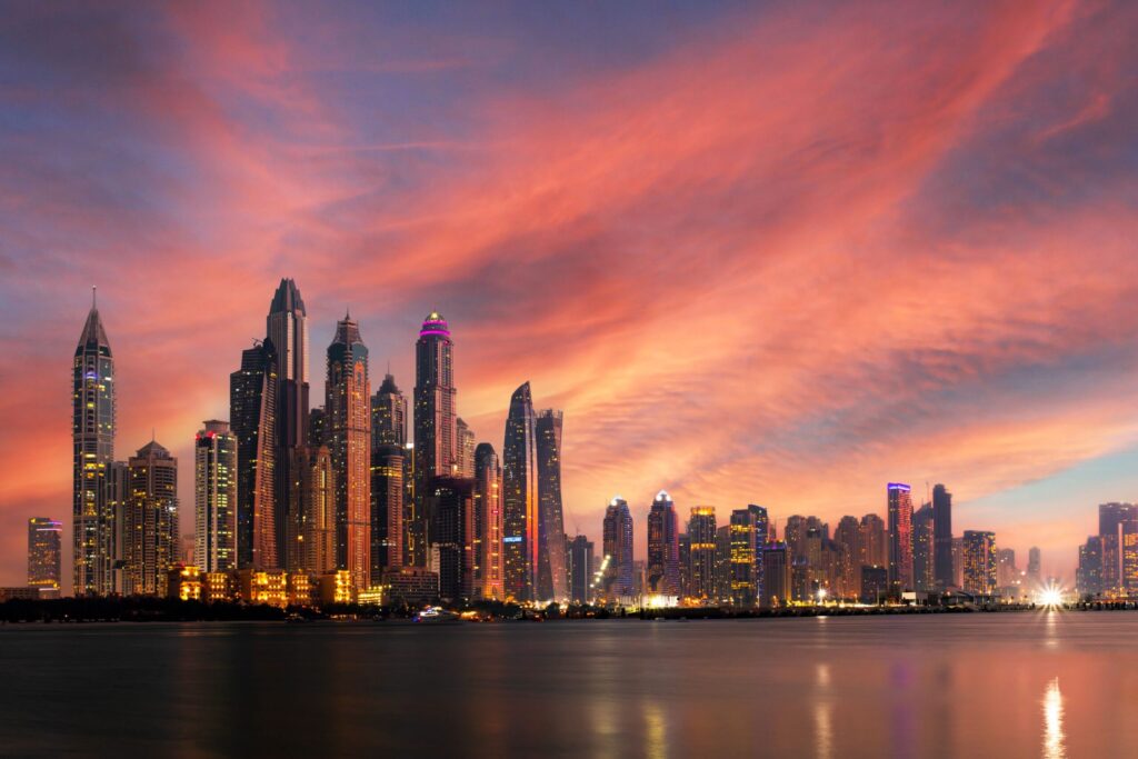 Dramatic sunset sky over the Dubai Marina skyscraper skyline reflected on the water, near Le Reve