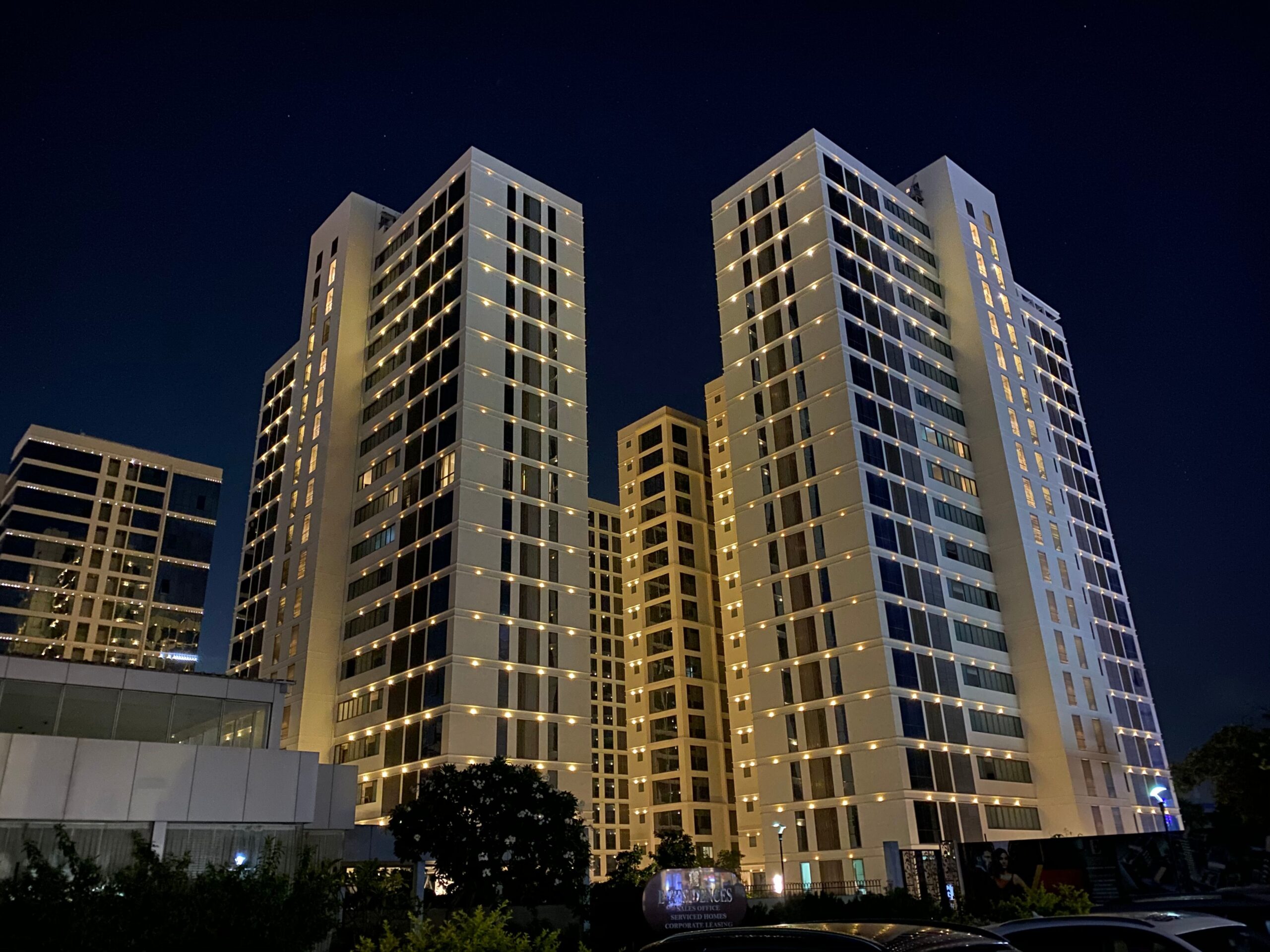 Illuminated modern residential towers at night near Tonino Lamborghini Residences, Meydan