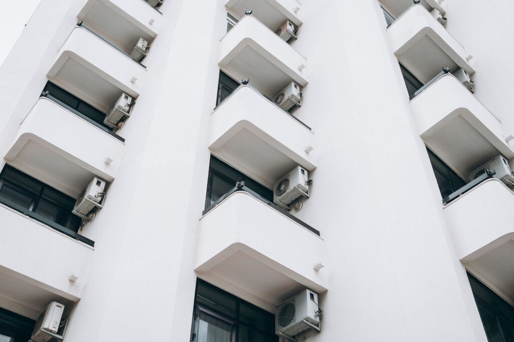 White apartment building with rounded balconies seen from below