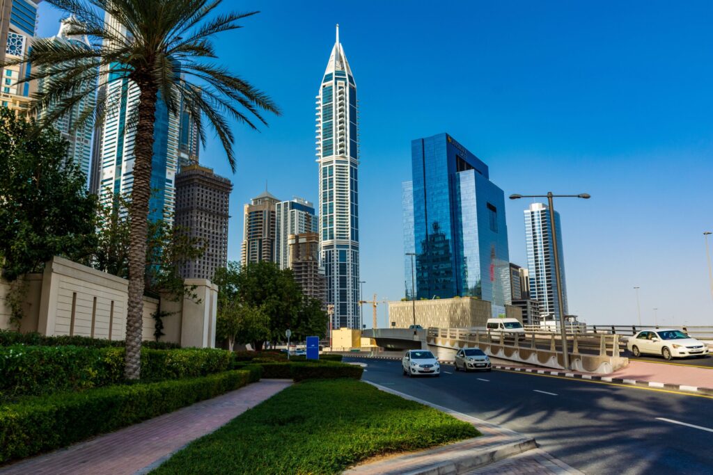 Sunny Dubai Marina street with a palm tree, high-rise towers and light traffic, similar cityscape setting to Park Vista's JVC neighbourhood