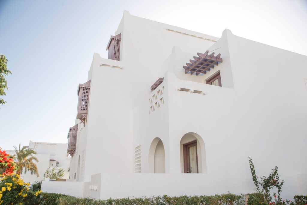Bright white Arabian-style villa exterior with arches and greenery