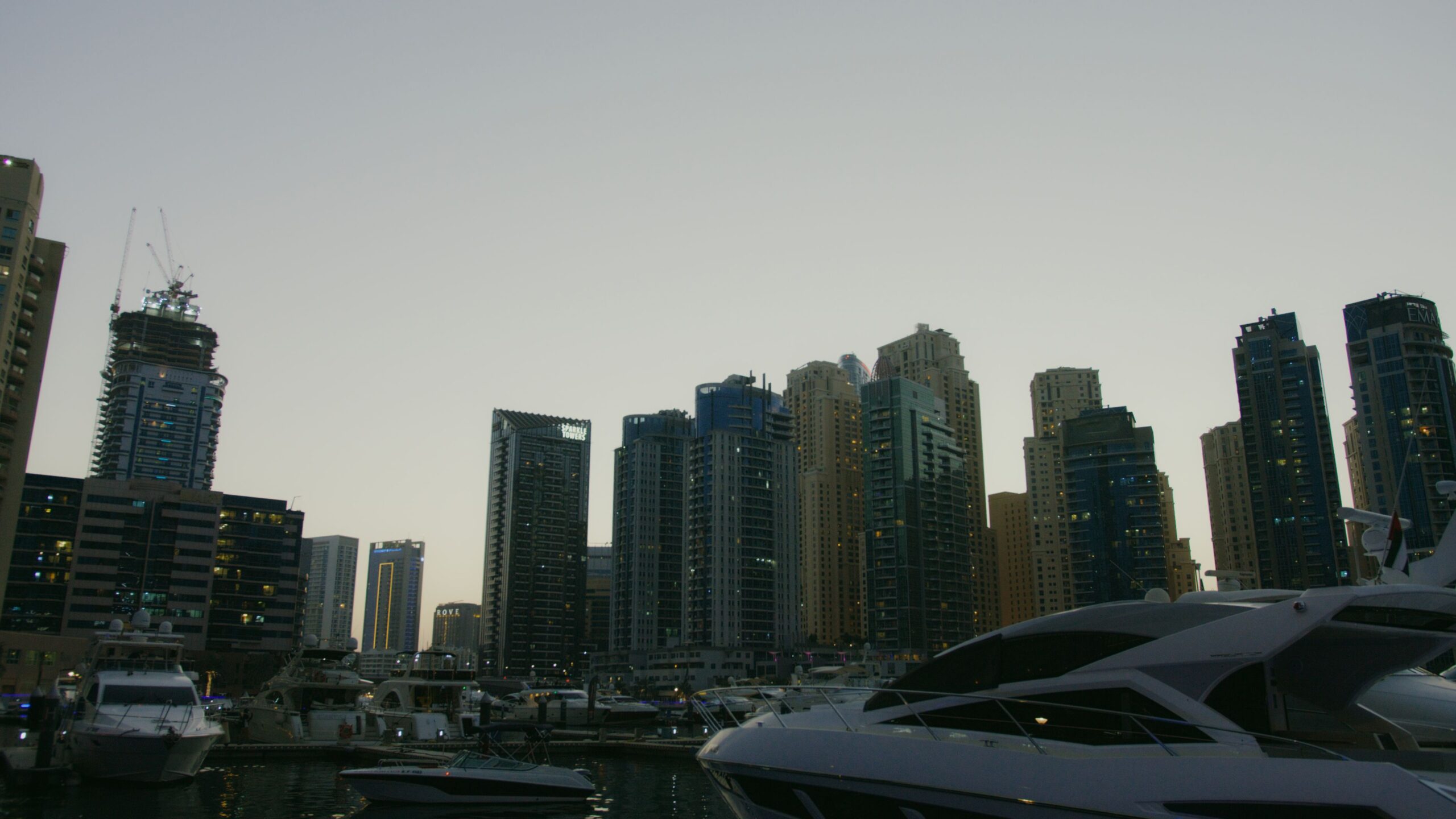 Waterfront residential towers and moored yachts at dusk, representative of Lakeshore Tower's Cluster Y setting in Jumeirah Lake Towers, Dubai