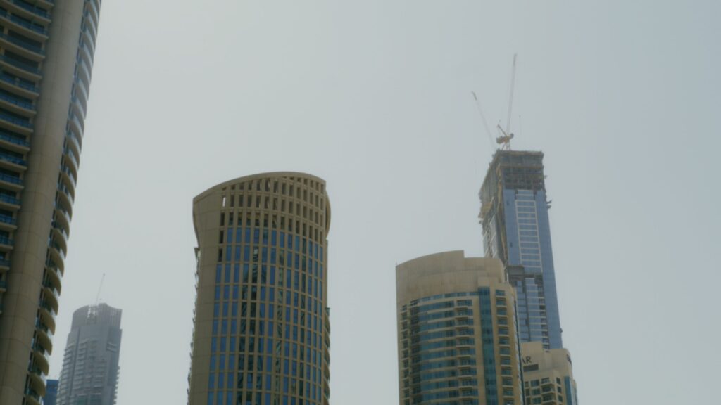 Modern Dubai high-rise tower under construction with a crane, near Skyscape Aura, Sobha Hartland II