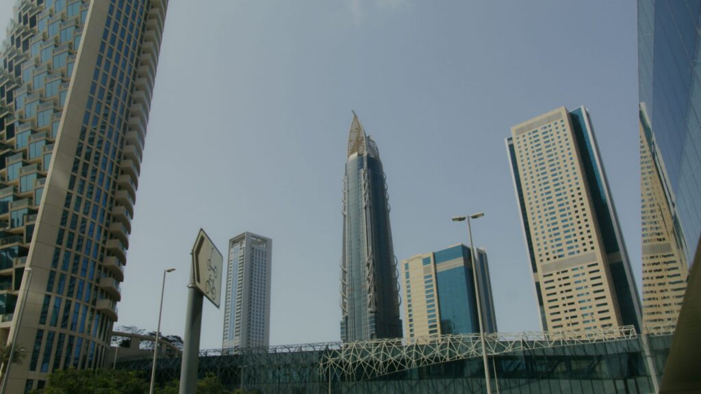 Low angle view of modern Dubai high-rise towers against a clear blue sky, Business Bay