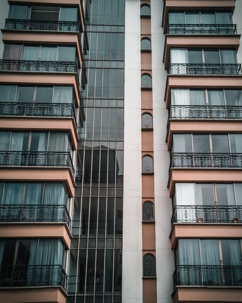 Low angle view of a modern apartment building with glass windows and balconies in Dubai